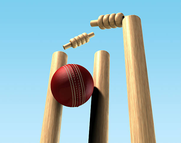 A Red Leather Cricket Ball Hitting Wooden Cricket Wickets